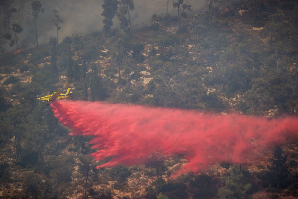 Aviões de combate a incêndios tentam extinguir um grande incêndio florestal que eclodiu perto de Neve Ilan, nos arredores de Jerusalém, em 9 de junho de 2021.