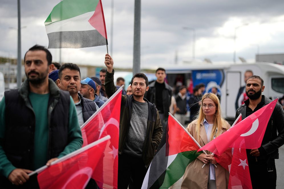 يلوح الناس بالأعلام التركية والفلسطينية أثناء تجمعهم خارج مطار إسطنبول، في انتظار وصول 137 ناشطًا من أسطول الصمود العالمي، في إسطنبول، تركيا، السبت 4 أكتوبر/تشرين الأول 2025