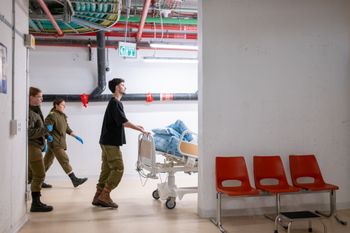 Medical staff at Shaare Zedek Medical Center and soldiers transfer patients back to regular wards after the underground department established during the war was closed, in Jerusalem, April 10, 2026