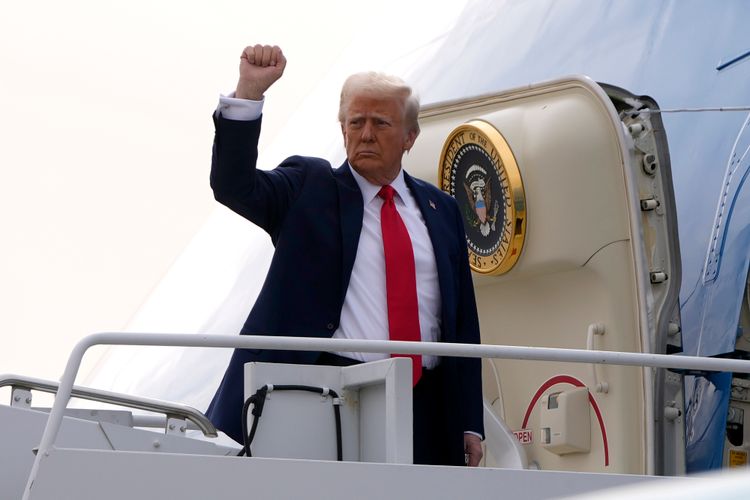 US President Donald Trump gestures as he boards Air Force One en route to Florida at Harry Reid International Airport in Las Vegas