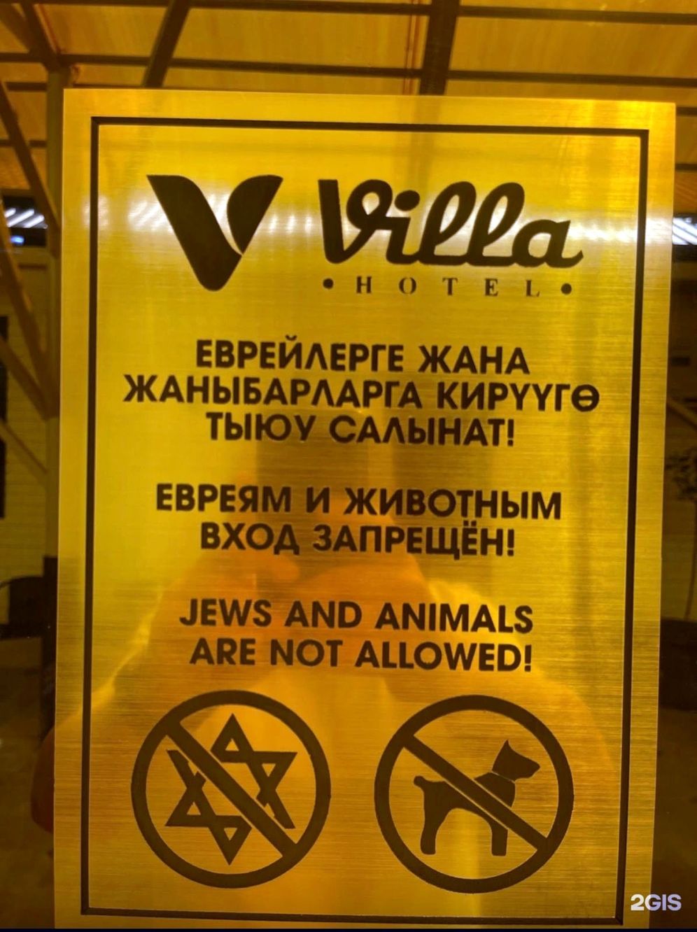 Le panneau notifiant l'interdiction d'entrée "aux Juifs et aux chiens"