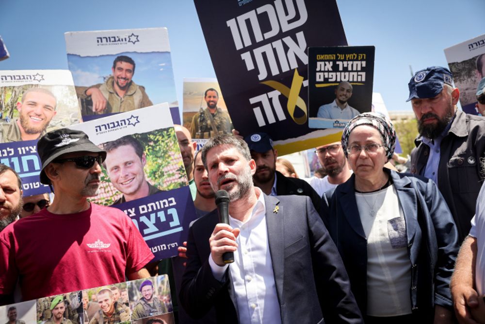 Israeli Finance Minister Bezalel Smotrich speaks with bereaved families of Israeli soldiers killed in the Gaza Strip who are protesting outside the Prime Minister's office in Jerusalem, calling for the continuation of the war.