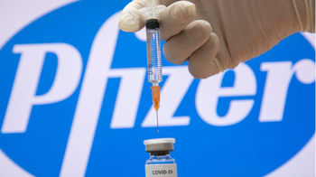 A photo illustration of a syringe and and a bottle reading "Covid-19 Vaccine" next to the Pfizer company logo in Jerusalem on December 10, 2020.