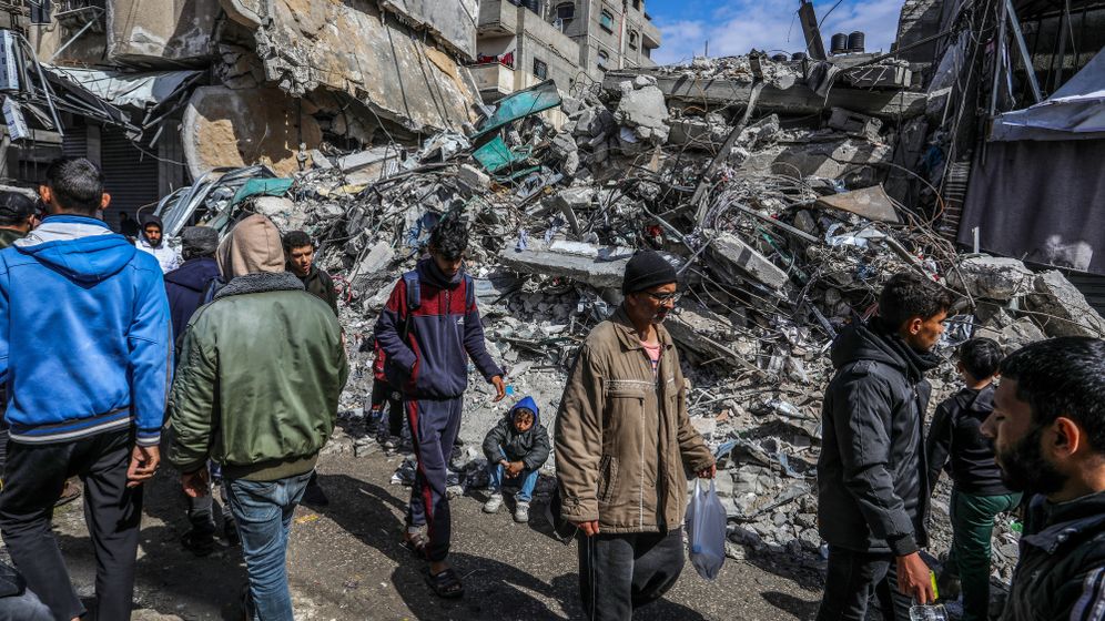 فلسطينيون قرب منازل مهدمة في غزة - ارشيف