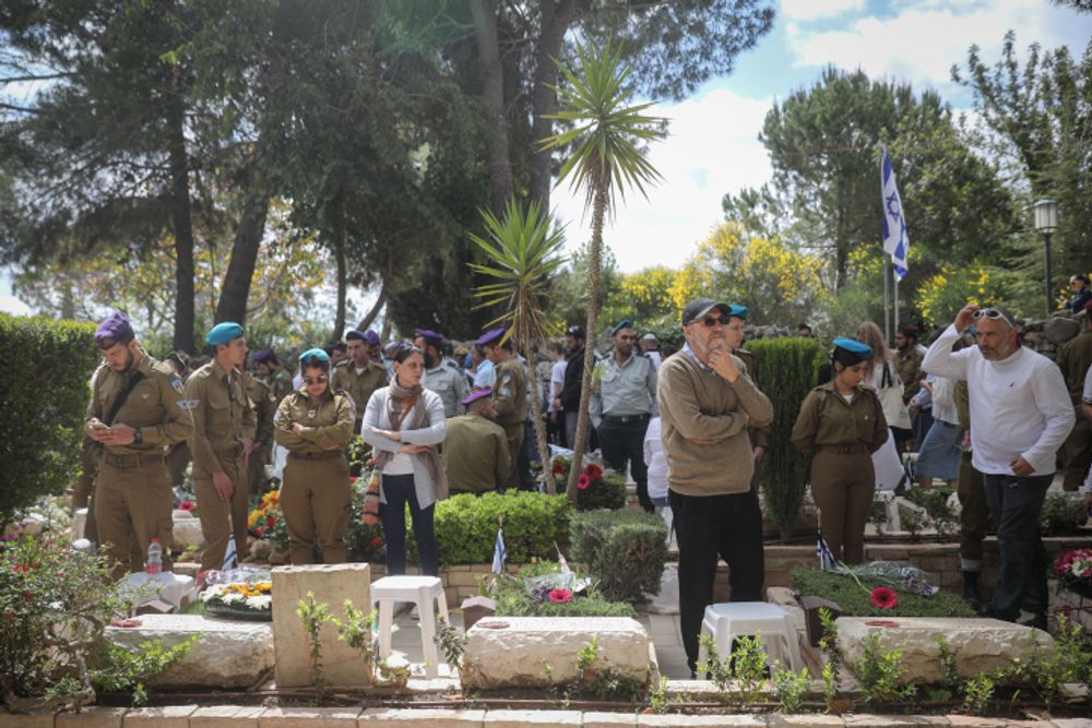 Bereaved Israelis mourn next to graves of fallen soldiers at the Mt Herzl military cemetery in Jerusalem, during Israeli Memorial Day, May 8, 2019.