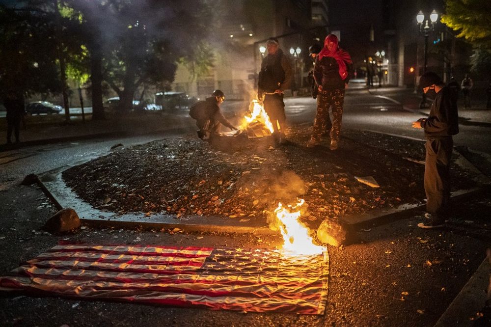 Illustrative: A burning American Flag in front of the Multnomah County Justice Center, in Portland, Oregon, on November 4, 2020.