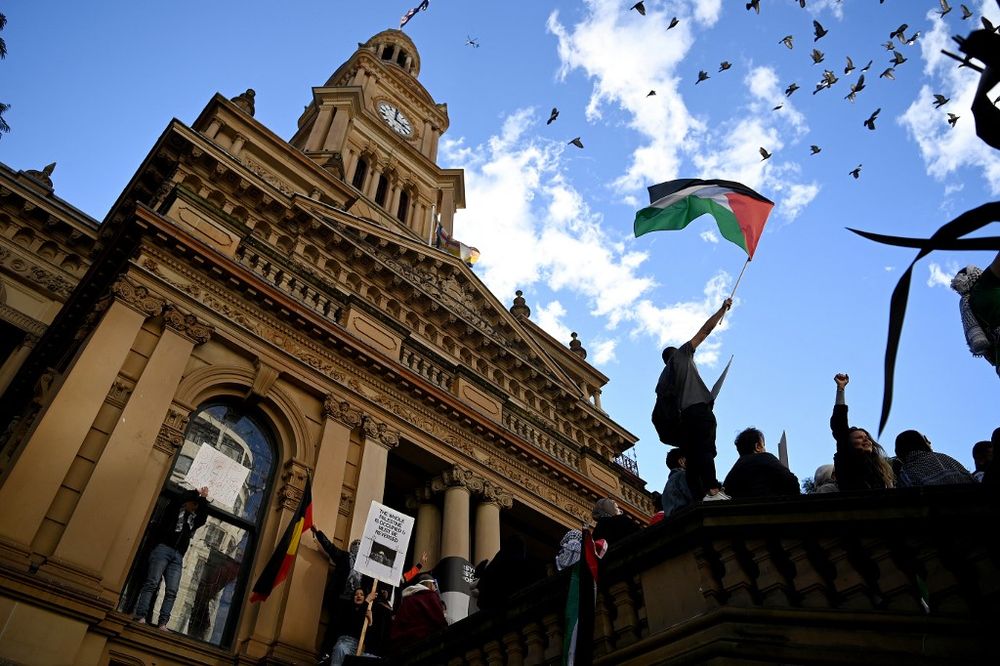 A protester waves a Palestinian flag during a demonstration against Israel at the Town Hall in Sydney, Australia, on May 15, 2021.