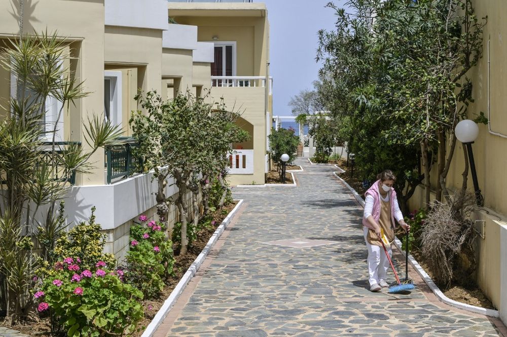 An employee cleans a patch at a bungalow hotel near the town of Chania on Crete island, on April 21, 2022.