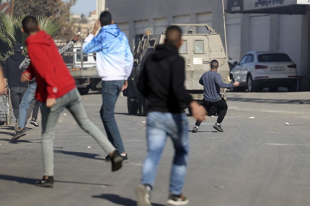 Palestinians throw stones at Israeli army vehicles in the West Bank.