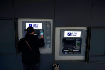 A man uses an ATM outside a closed bank in Beirut, Lebanon, March 21, 2022.