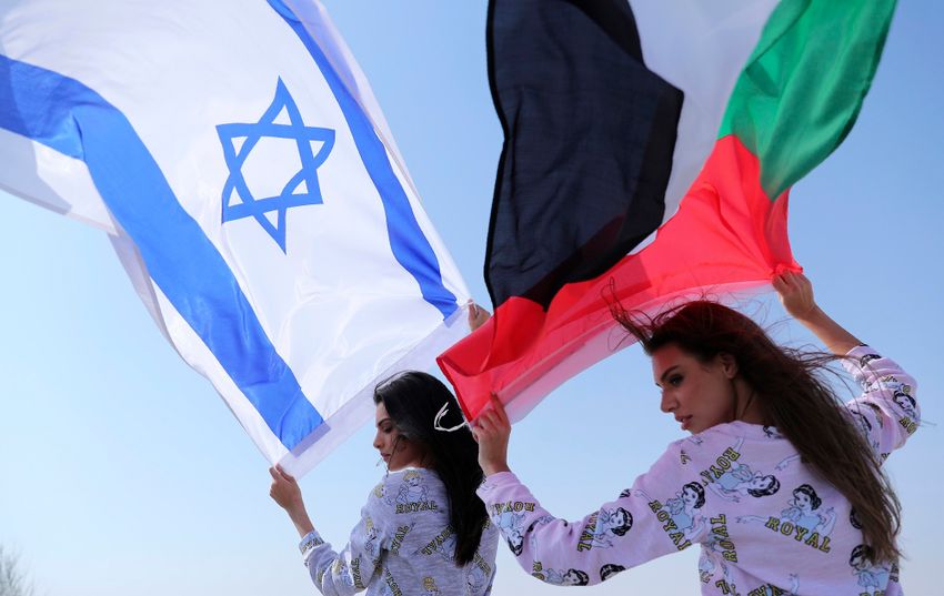 Israeli model May Tager, left, holds Israel's flag while next to her Anastasia Bandarenka, a Dubai-based model originally from Russia, in Dubai, United Arab Emirates, Sunday, Sept. 8, 2020.