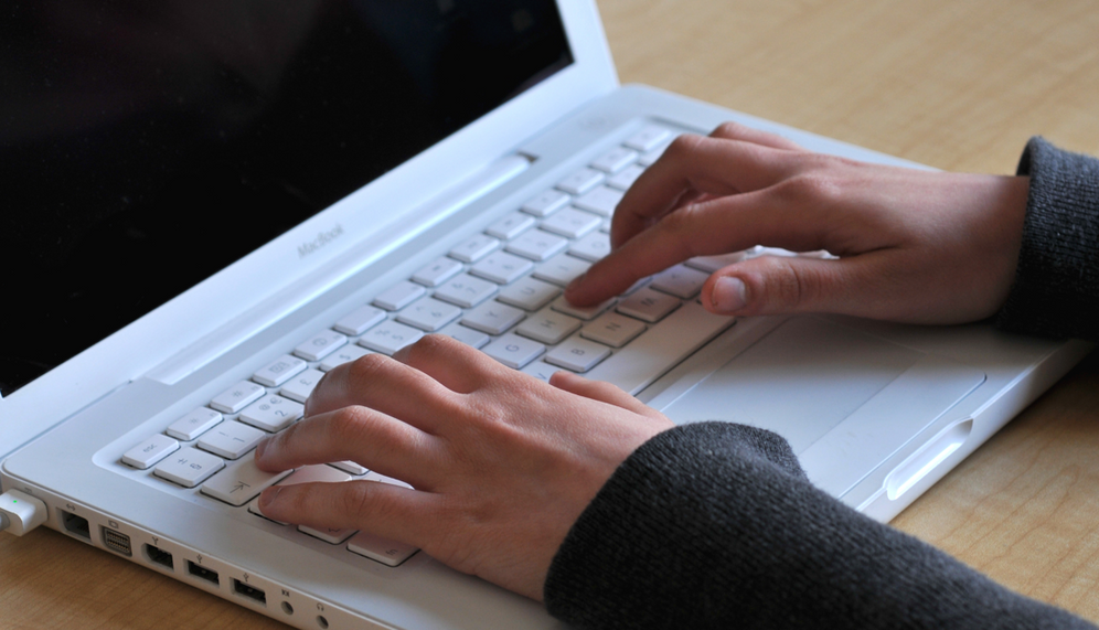 Illustration d'une femme tapant sur un ordinateur Apple Macbook à un bureau, le 24 mars 2011.