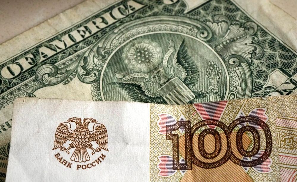 One hundred rubles banknote is pictured in front of a one US dollar banknote, Gelsenkirchen, Germany, Monday, April 25, 2022.