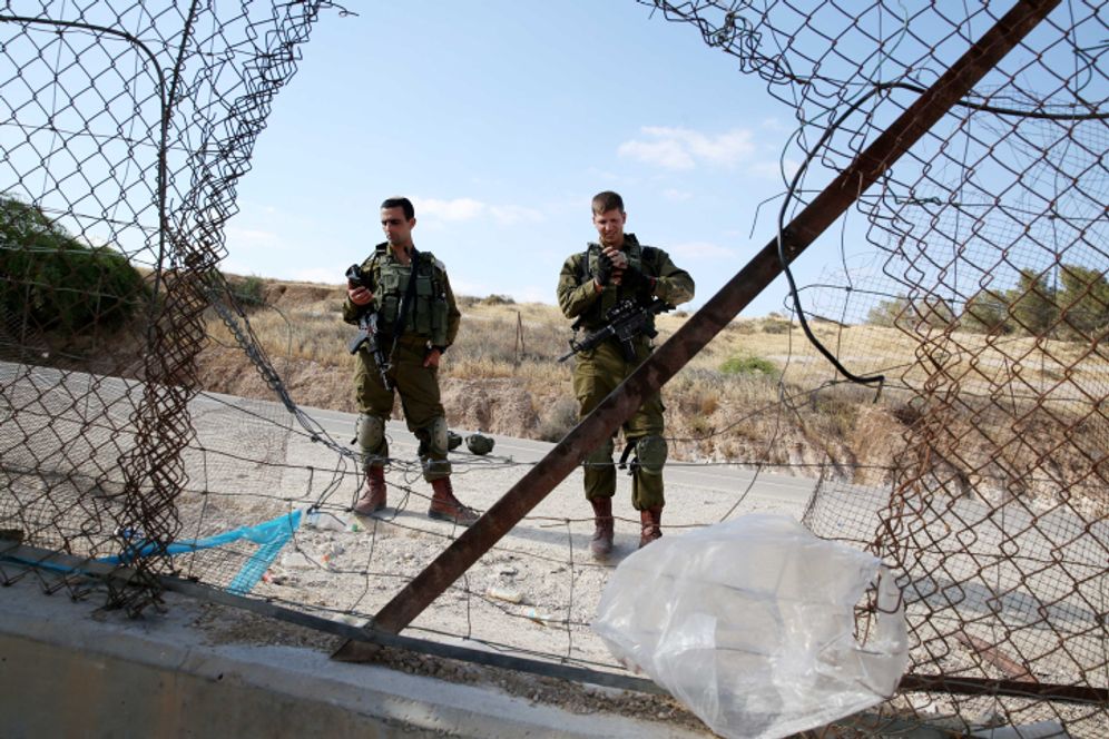 Israeli security forces prevent Palestinians from crossing into Israel through a hole in the security fence near the West Bank city of Hebron, May 23, 2021.