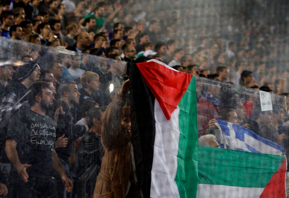 AP Photo/Petros Giannakouris holding Palestinian Flags during soccer game