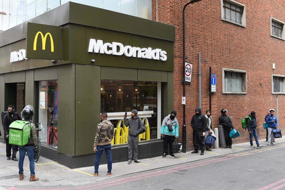Delivery riders queue up outside a McDonald's restaurant in east London, UK, on May 13, 2020.