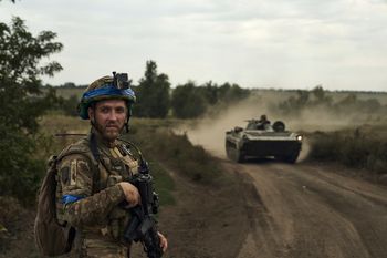 A soldier of Ukraine's 3rd Separate Assault Brigade looks on against the background of an APC near Bakhmut, in the Donetsk region, Ukraine.