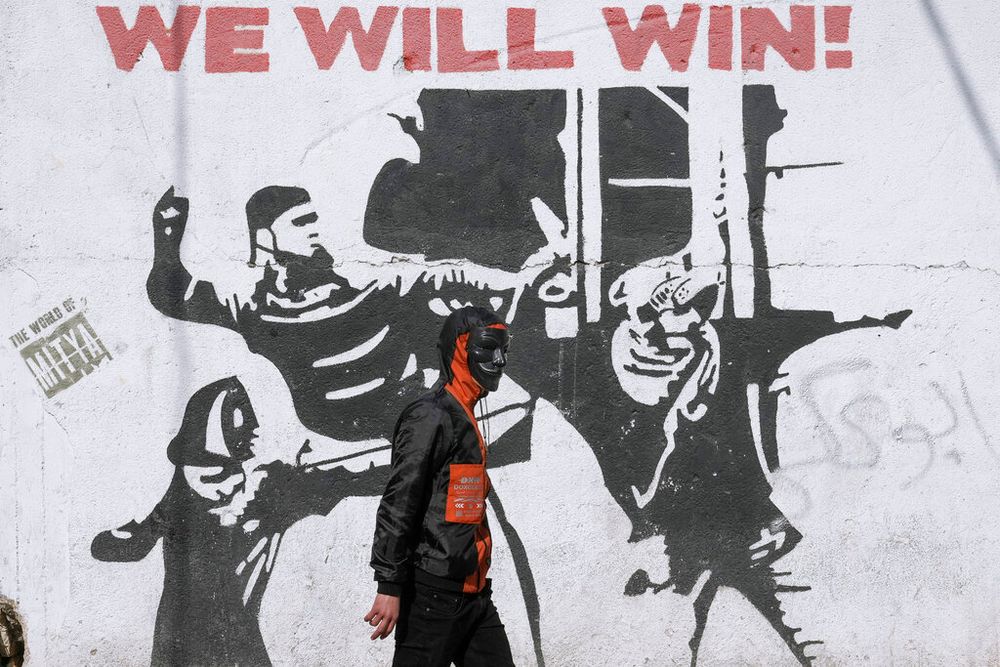 A masked Palestinian demonstrator takes part in a protest against an Israeli army raid in the West Bank city of Bethlehem.
