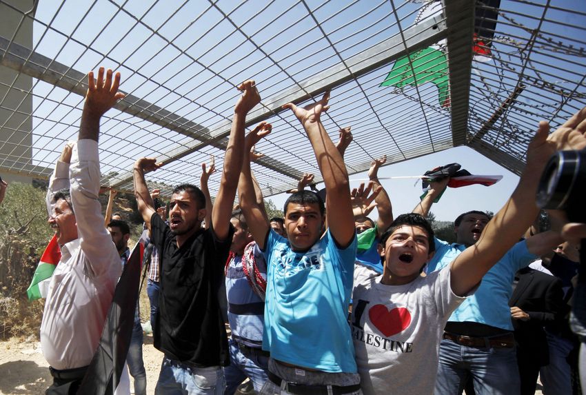 Palestinians carry part of a fence during a demonstration against the separation barrier, in the West Bank village of Beit Jallah, near Jerusalem, Sunday, Aug. 23, 2015.