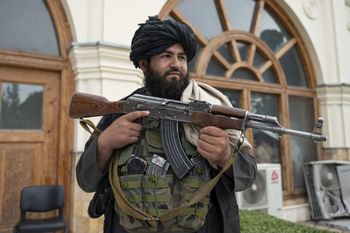 A Taliban fighter stands guard after a gathering at the former presidential palace in Kabul, Afghanistan on August 13, 2022.