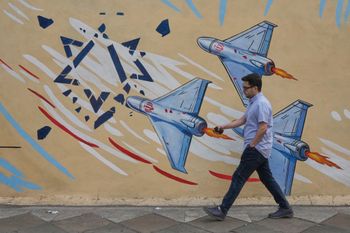 A man walks past an anti-Israel mural in downtown Tehran, Iran, Sunday, May 17, 2026. 
