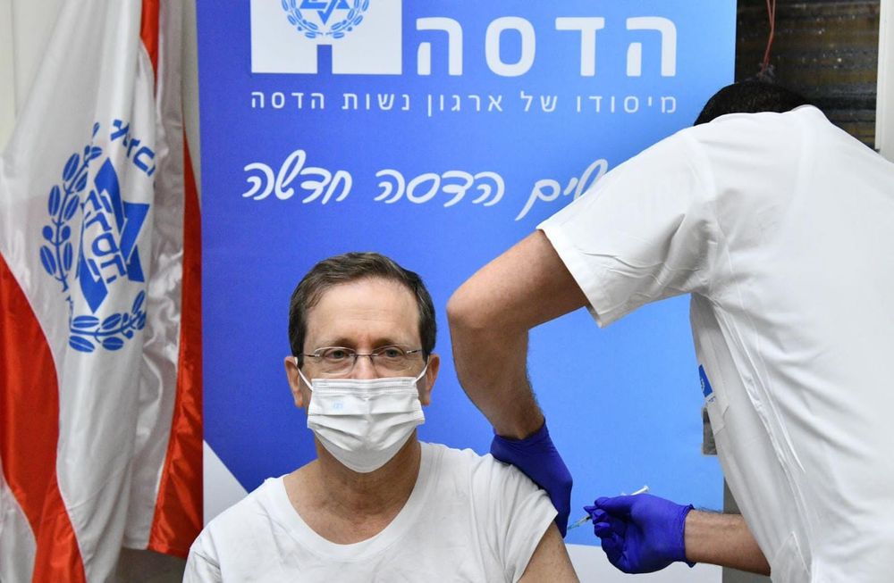 Israel's President Isaac Herzog receives a second booster dose of the coronavirus vaccine at Hadassah Ein Kerem Medical Center in Jerusalem on January 5, 2022.