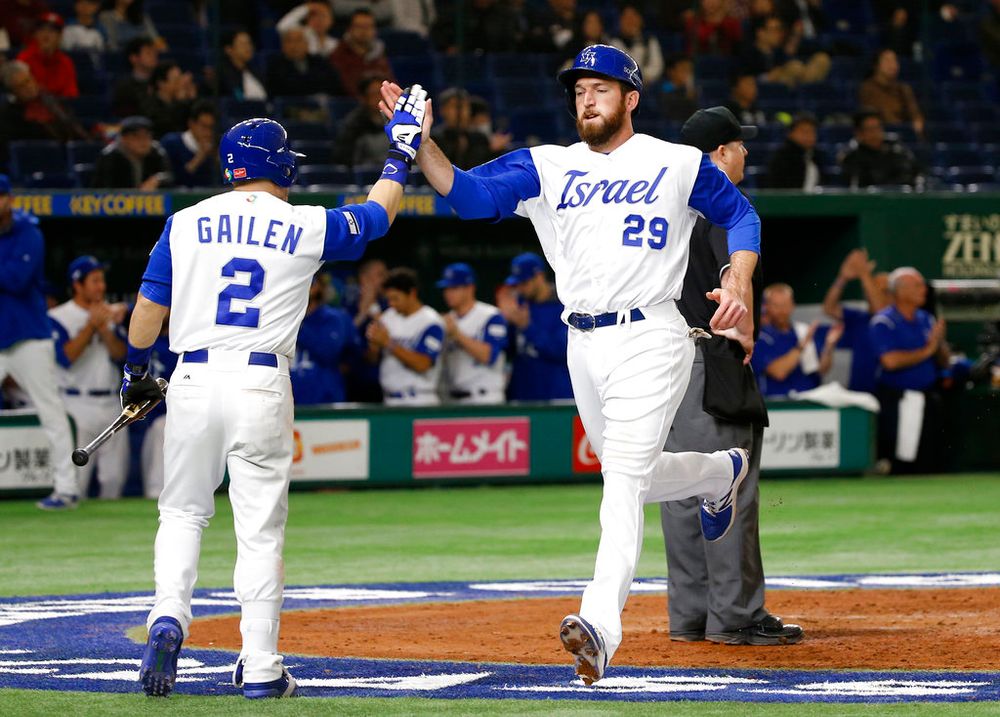Israel's Ike Davis (R) celebrates with teammate Tyler Krieger after scoring against Cuba during the World Baseball Classic at the Tokyo Dome, Japan.
