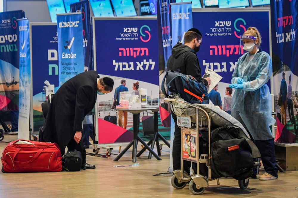 Medical technicians test passengers for Covid-19 at the Ben Gurion International Airport near Tel Aviv on March 8, 2021.