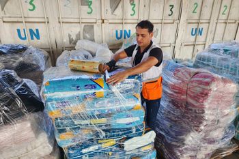 File photo of Palestinian aid workers preparing humanitarian aid for distribution at the Deir al-Balah UNRWA warehouse in the Gaza Strip