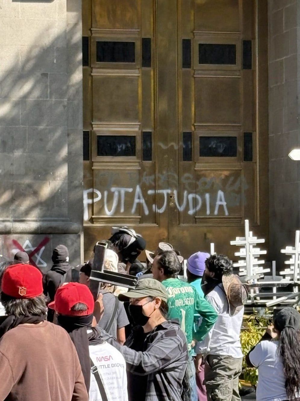 Protestors spraypaint the words 'Jewish Whore' onto the gates of the Presidential Palace in Mexico
