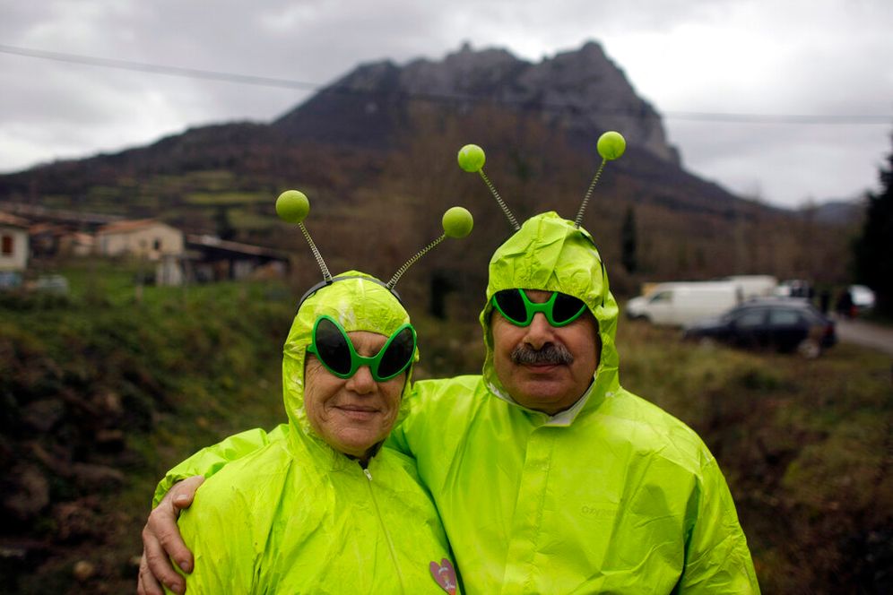 People dressed in alien costumes pose for a photo in front of Pic de Bugarach mountain at a small party in the town of Bugarach, France.