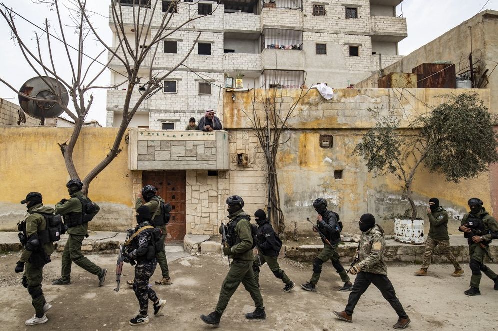 Syrian Kurdish Asayish security forces search houses during a raid against suspected Islamic State group fighters in Raqa, the jihadist group's former de facto capital in Syria.