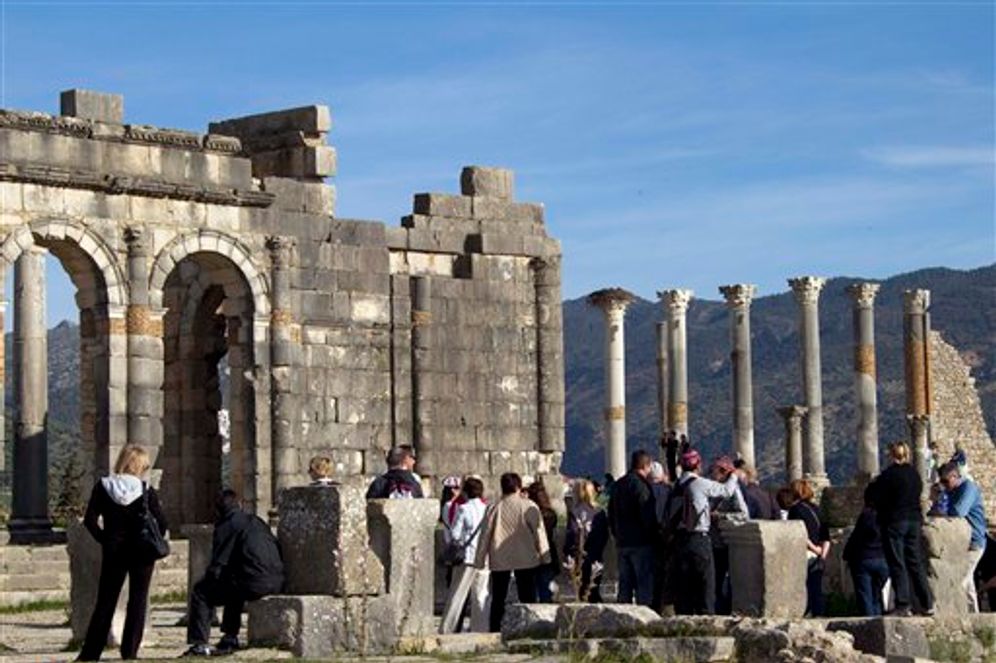 يتجمع السياح حول أقواس الكاتدرائية، المبنى الإداري الرئيسي لفولوبيليس، الخراب الروماني الأكثر شهرة في المغرب بالقرب من مكناس، المغرب. موقع Volubilis هو واحد من أفضل المواقع المحفوظة في المغرب والأكثر زيارة.