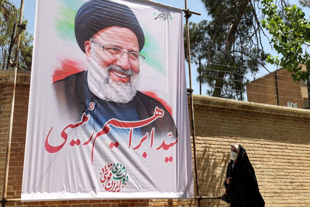 An Iranian woman walks past an electoral poster depicting presidential candidate Ebrahim Raisi in the capital Tehran, on May 29, 2021.