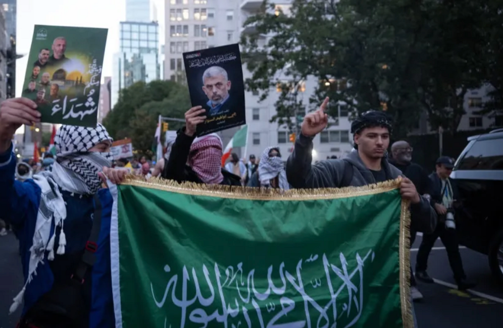 (credit: Joseph Strauss/JTA) Pro-Palestinian protesters hold a Hamas flag and a photo of Yahya Sinwar, the mastermind of the Oct. 7, 2023, attack as they march toward Union Square.