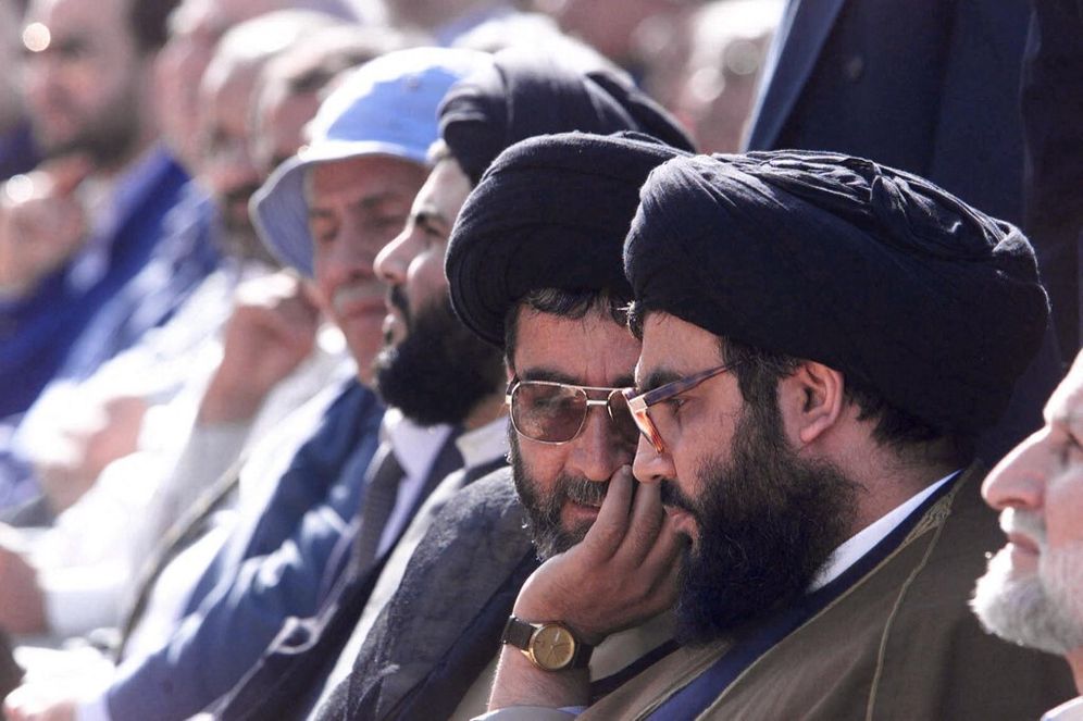 زعيم حزب الله اللبناني الشيخ حسن نصر الله (يمين) يتحدث إلى الشيخ الأمين السيد (الثاني يمين) خلال تجمع جماهيري في بلدة بنت جبيل الحدودية في 26 مايو 2000