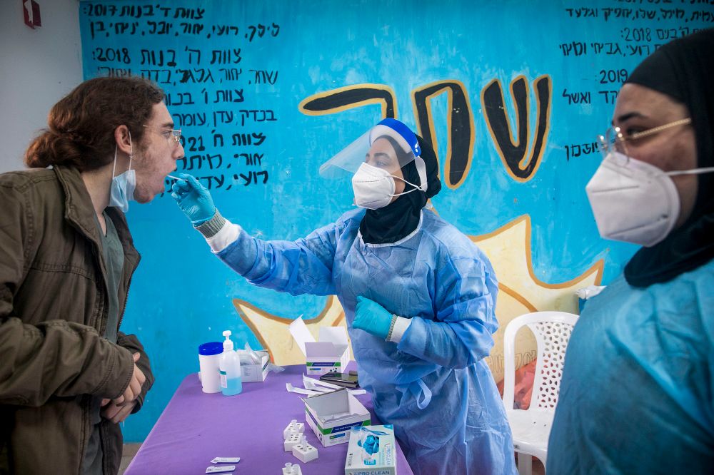 A medical worker takes a Covid-19 rapid antigen test from Israelis, at a testing center in Beit Hashmonai, on January 16, 2022.