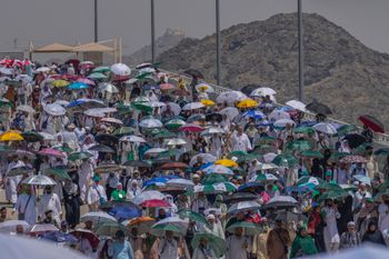 Muslim pilgrims use umbrellas to shield themselves from the sun as they arrive to cast stones at pillars in the symbolic stoning of the devil, the last rite of the annual hajj, in Mina, near the holy city of Mecca, Saudi Arabia, Tuesday, June 18, 2024.