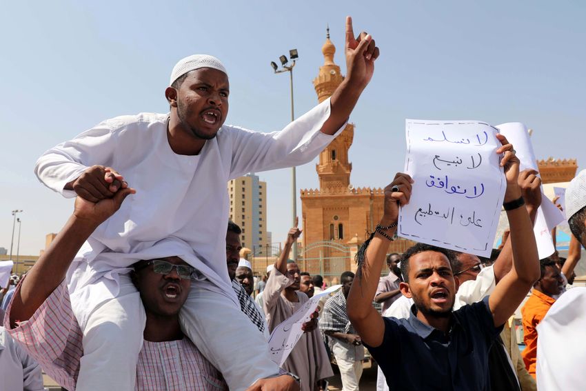 رجل يحمل ملصقًا كتب عليه لن نستسلم ولن نبيع ولن نوافق على التطبيع، الخرطوم، السودان.