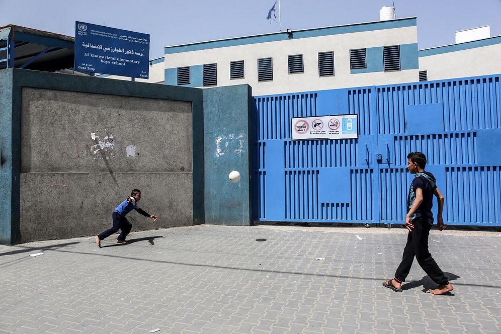 FILE PHOTO. Children play near the closed gate of a school run by the UNRWA in Rafah, southern Gaza Strip.