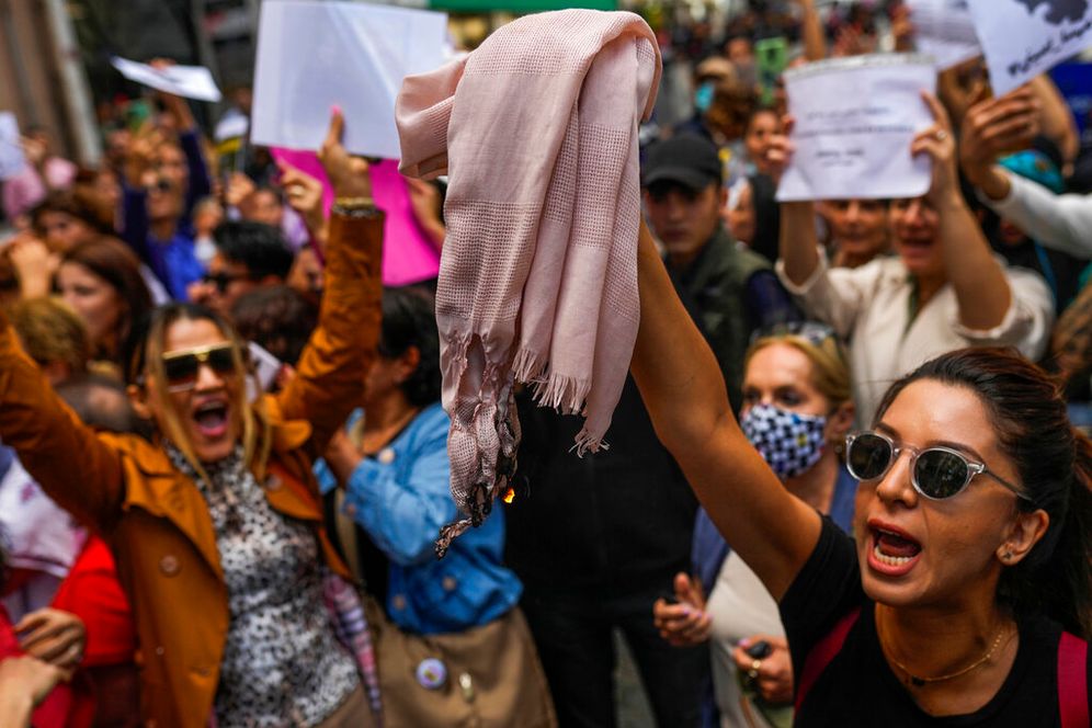 A woman burns a hijab during a protest against the death of Mahsa Amini, outside Iran's general consulate in Istanbul, Turkey.