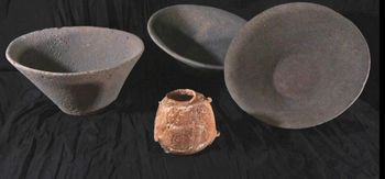 Ivory vessel, dating to 6,000 years ago, next to large basalt bowls in which it was found hidden.