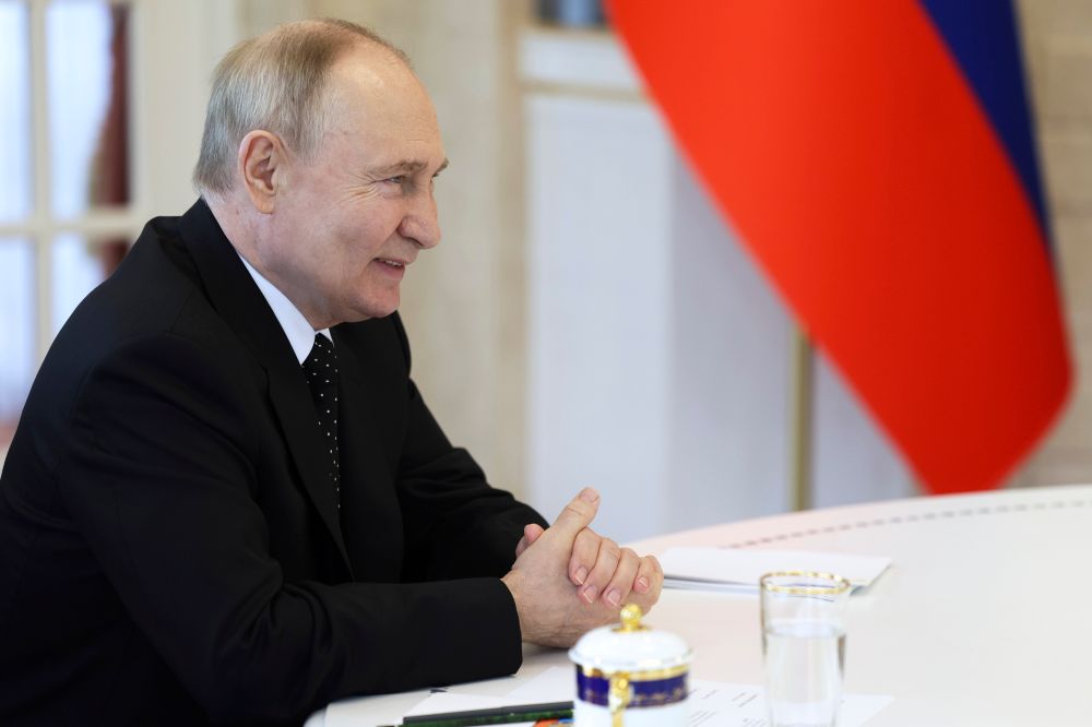 Russian President Vladimir Putin smiles as he talks with North Korea's leader Kim Jong Un during their meeting in Pyongyang, North Korea