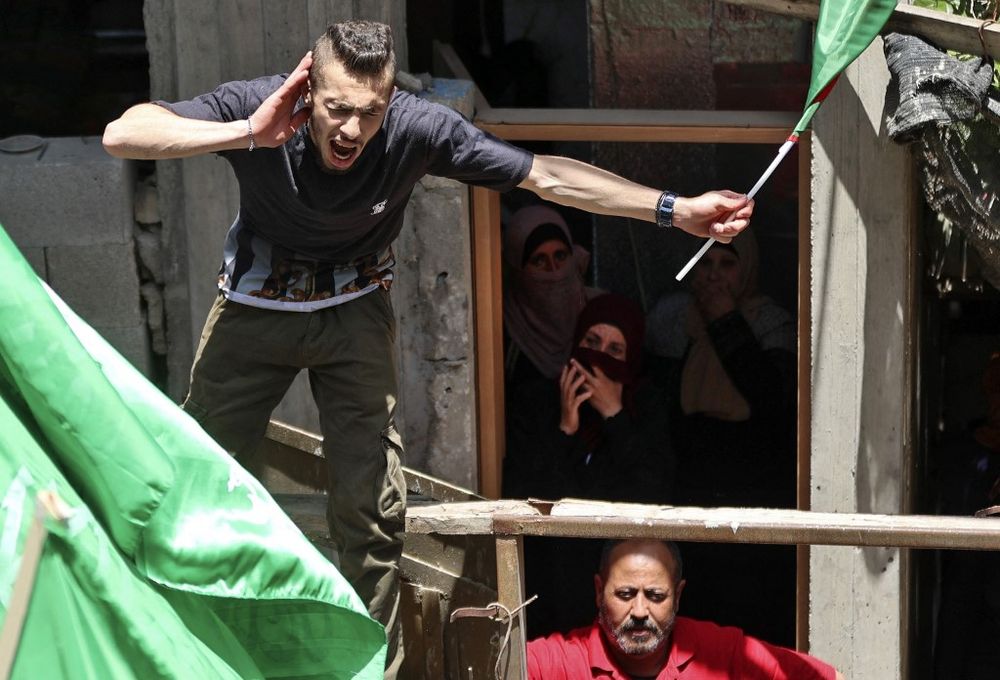 Palestinians wave the Hamas flag in the village of Aqaba near Nablus, in the north of the West Bank on May 12, 2021.