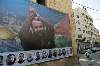 Une banderole avec une photo du leader du soulèvement palestinien emprisonné Marwan Barghouti et de quelques codétenus, accrochée sur un bâtiment, dans la ville de Ramallah, en Cisjordanie, le lundi 1er mai 2017