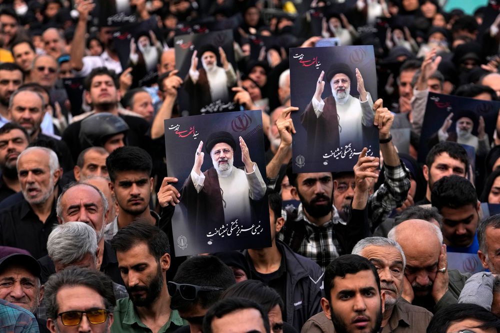People hold up posters of President Ebrahim Raisi during a mourning ceremony for him at Vali-e-Asr square in downtown Tehran, Iran, Monday, May 20, 2024.