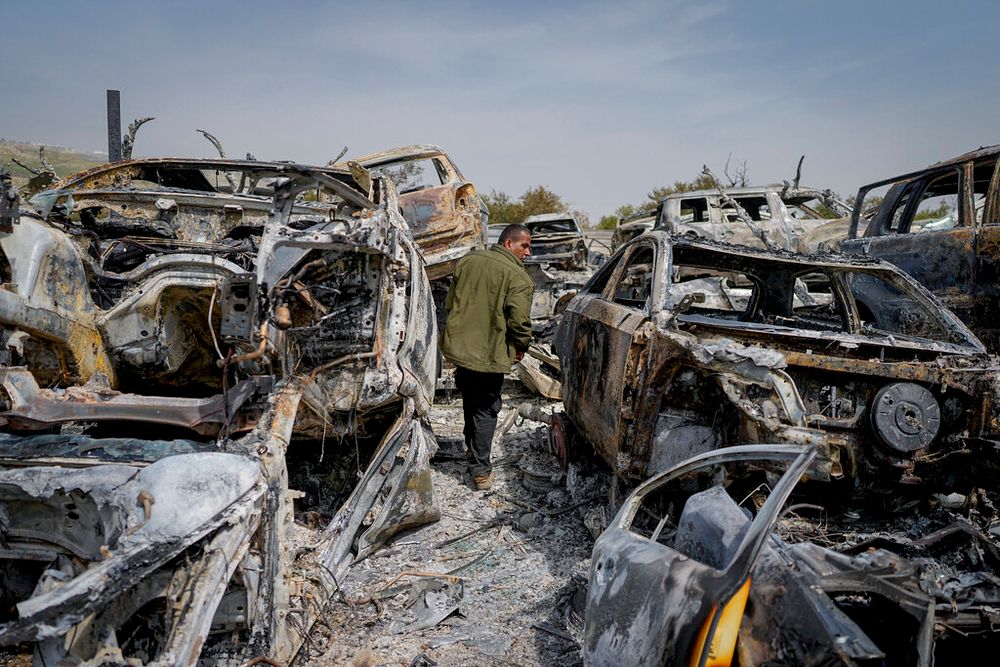 A Palestinian man walks between scorched cars in a scrapyard, in the town of Huwara, near the West Bank city of Nablus.