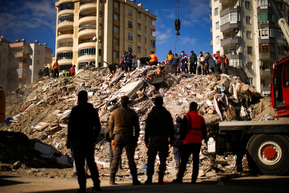 Emergency rescue members search for people in a destroyed building in Adana, Turkey.
