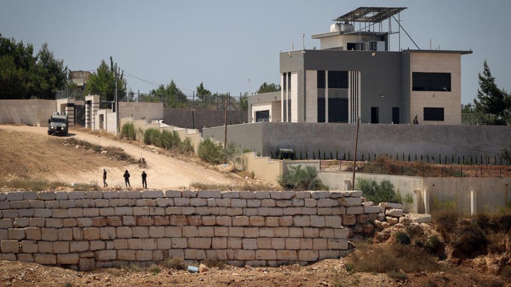FLASH90 Des habitants des implantations israéliennes se rassemblent devant les maisons palestiniennes qu'ils assiègent dans le village de Qusra, en Judée-Samarie, le 13.08.2026