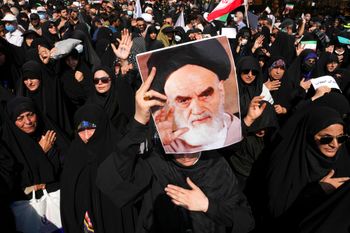A pro-government demonstrator holds a poster of the late Iranian revolutionary founder Ayatollah Khomeini while attending a rally to condemn anti-government protests in Tehran, Iran, on September 23, 2022.